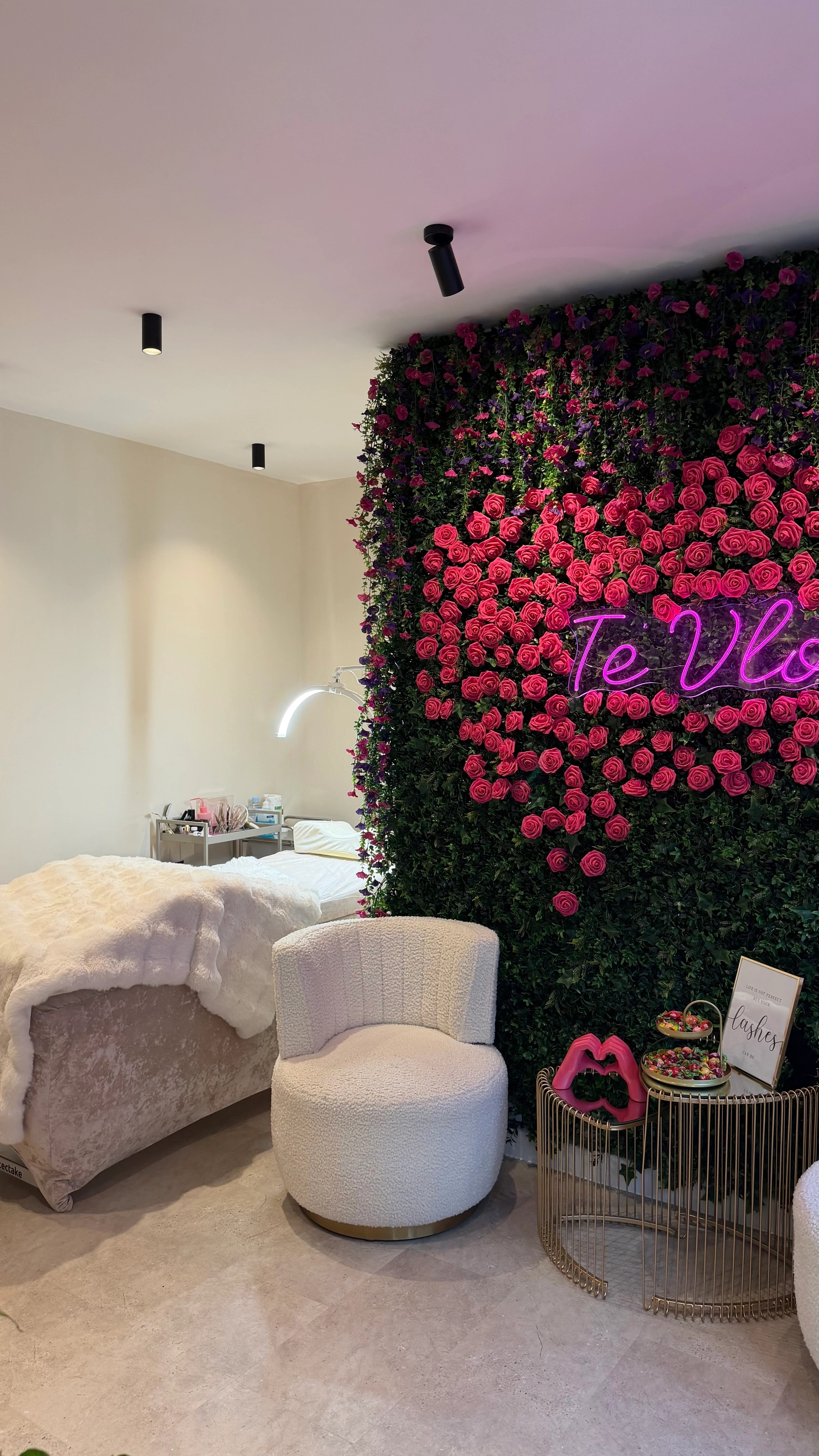 Behandlungsraum von Te Vlora mit Rosenwand und Neon-Schriftzug